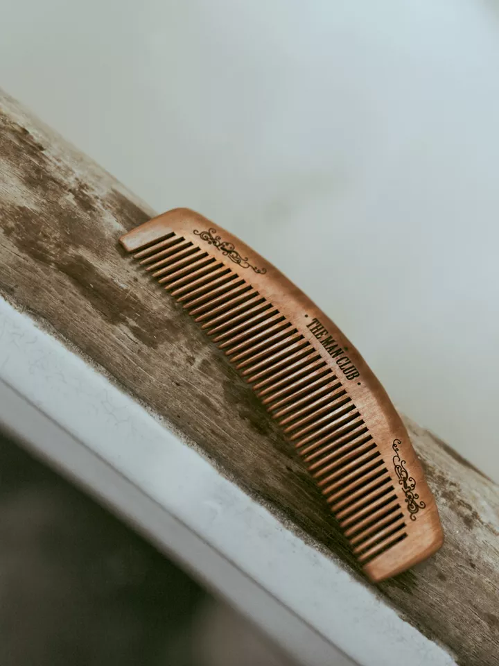A wooden barber's comb resting on a ledge